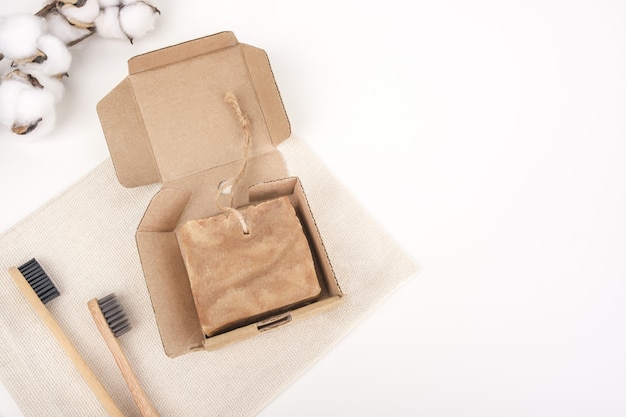 Jabón y cepillos de dientes de madera sobre un fondo blanco.