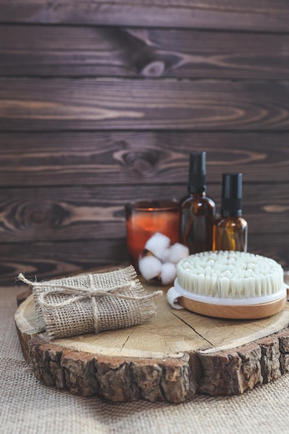Jabón natural hecho a mano y cepillo de masaje con aceites sobre un fondo de madera Concepto de relajación SPA