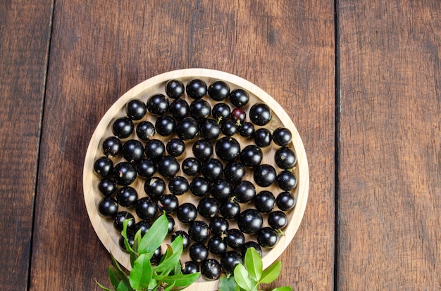 Jabuticaba, Jabuticabas recém colhidas em potes e cestos dispostos em madeira rústica, vista de cima.