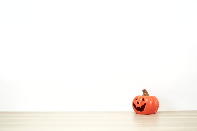 Jack o lantern adorável na decoração de uma prateleira ou mesa com parede branca com