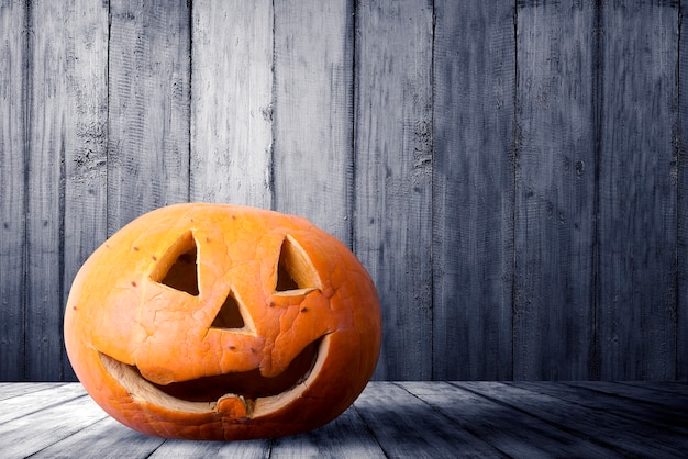 Jack-o-Lantern sobre mesa de madera con fondo de pared