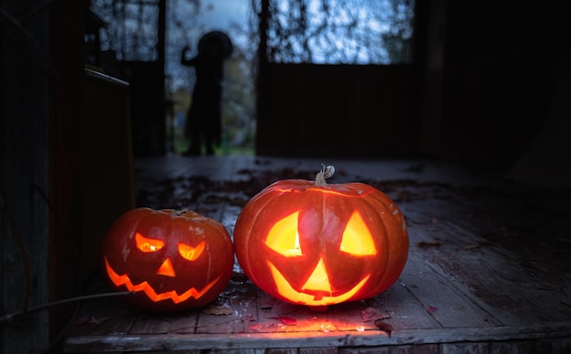 Jackolantern hecho a mano con grandes calabazas con luces de velas en los ojos, nariz, boca, celebración de Halloween, corte con cuchillo, sacar pulpa con semillas, actividad al aire libre, patio trasero, fiesta infantil.