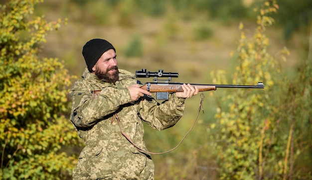 Jäger halten Gewehr Bärtige Jäger verbringen die Freizeitjagd Fokus und Konzentration des erfahrenen Jägers Jagd männliches Hobbykonzept Mann brutaler Wildhüter Naturhintergrund Regulierung der Jagd