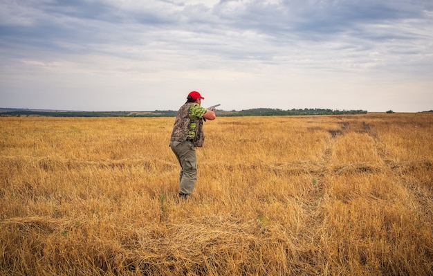 Jäger mit einer Waffe auf dem Feld und zielt auf die Beute