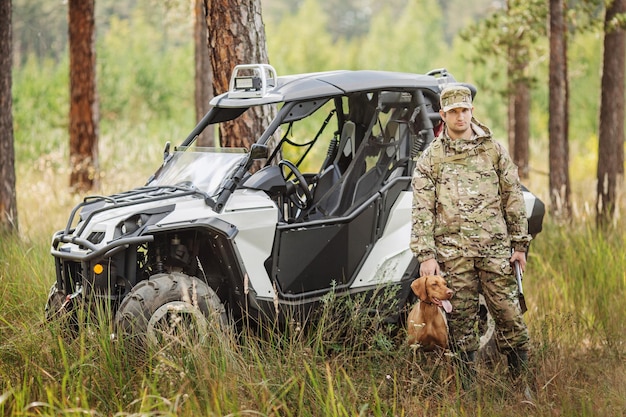 Jäger mit Gewehr und Vierradreifen im Wald