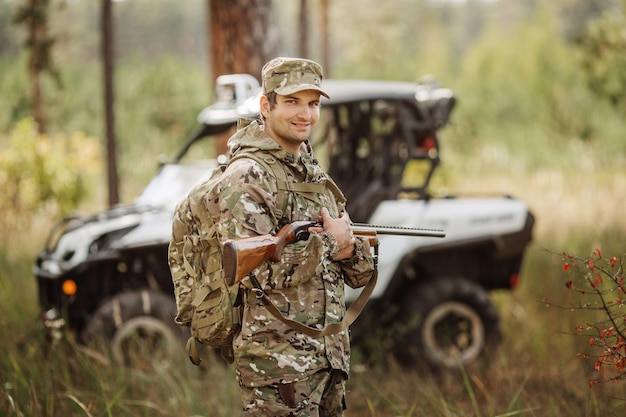 Jäger mit Gewehr und Vierradreifen im Wald