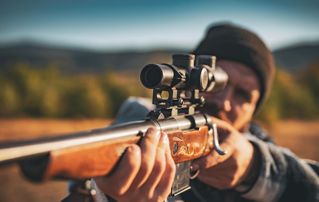 Jäger mit mächtigem Gewehr mit Zielfernrohr, das Tiere entdeckt Jäger mit Schrotflinte auf der Jagd Jäger im