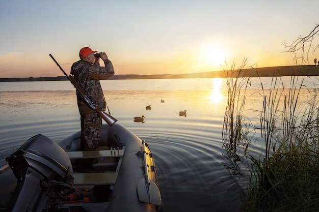 Jäger mit Schrotflinte Jagd auf Enten Entenjagd bei Sonnenaufgang