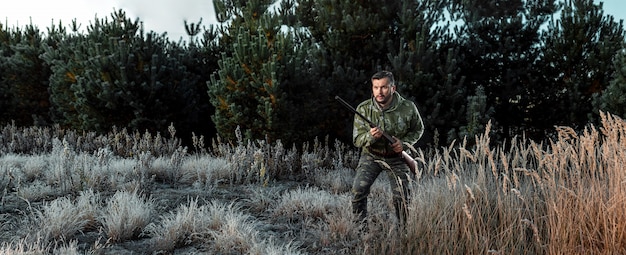 Jägermann in der Tarnung mit einer Gewehr während der Jagd