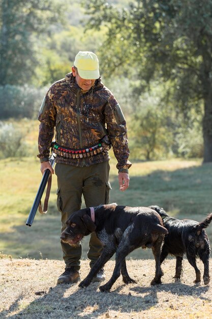 Foto jägermann in tarnung mit einer waffe während der jagd auf der suche nach wildvögeln oder wild herbstjagd