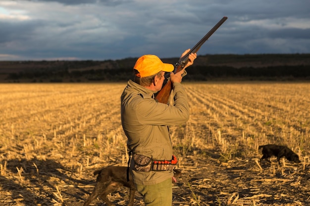 Jägermann in Tarnung mit einer Waffe während der Jagd auf der Suche nach Wildvögeln oder Wild