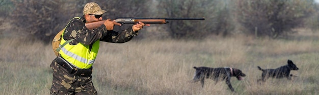 Foto jägermann in tarnung mit einer waffe während der jagd auf der suche nach wildvögeln oder wild