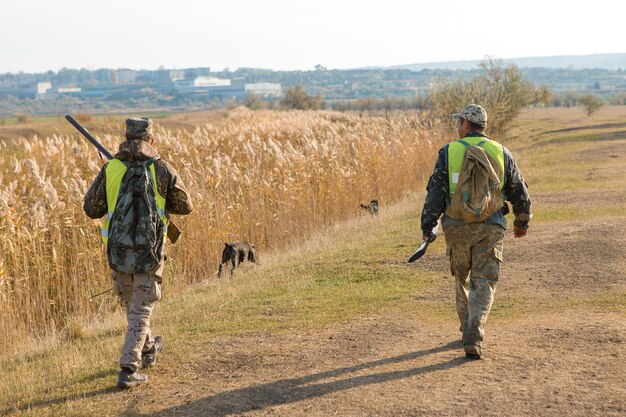 Jägermann in Tarnung mit einer Waffe während der Jagd auf der Suche nach Wildvögeln oder Wild