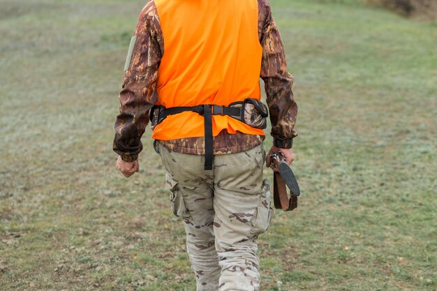 Jägermann in Tarnung mit einer Waffe während der Jagd auf der Suche nach Wildvögeln oder Wild.