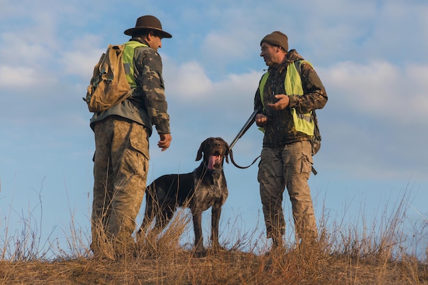 Jägermann in Tarnung mit einer Waffe während der Jagd auf der Suche nach Wildvögeln oder Wild