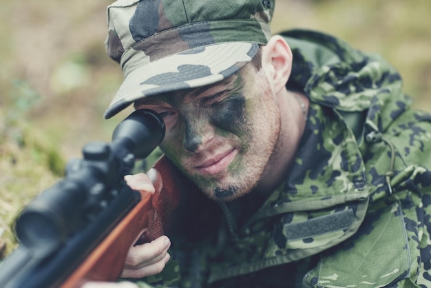 Jagd-, Kriegs-, Armee- und Personenkonzept - junger Soldat, Waldläufer oder Jäger mit Pistole im Wald