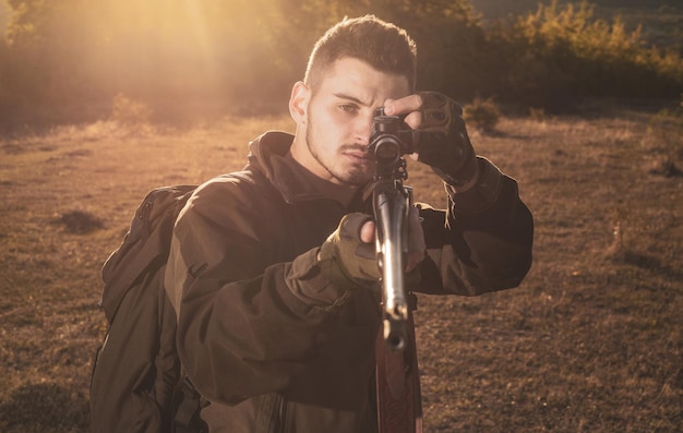 Jagdgewehrjäger mit Schrotflinte auf Jagdkalibern von Jagdgewehren spürt Porträt von Hamdso auf