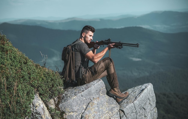 Jagdlizenzen illegaler Jagdwilderer im Wald hübscher Jägermann, der Gewehr hält und i geht