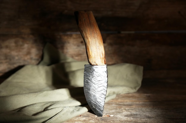 Jagdmesser und Sackleinen auf Holzhintergrund