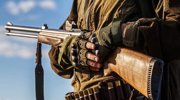 Jagdprozess während der Jagdsaison. Männlicher Jäger in bereit zu jagen. Nahaufnahme. Jäger Mann. Jagdzeit. Mann mit einer Waffe, Gewehr. Mann lädt ein Jagdgewehr auf.