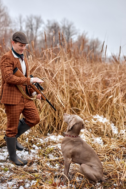 Jagdzeit, Herbstsaison geöffnet. männliche Jäger geben Befehle und trainieren den Hund