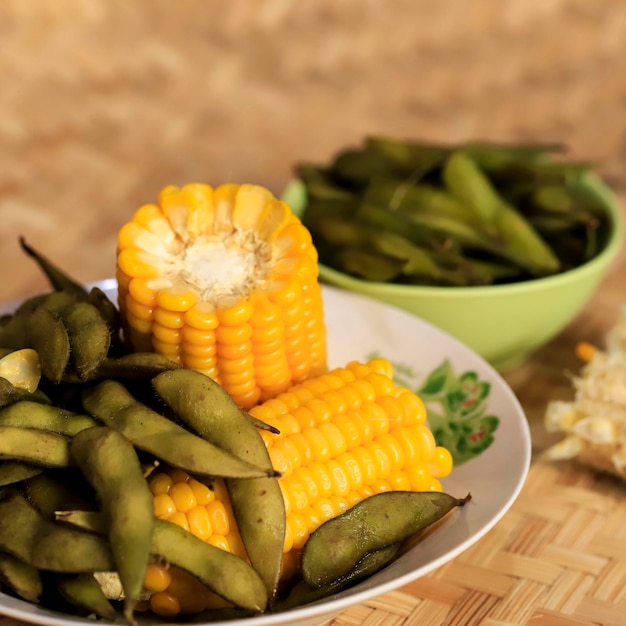 "Jagung und Kedelai Rebus" oder gekochter Edamame und Mais, indonesischer Snack für Tee oder Kaffee. Serviert in Vintage-Keramikplatte