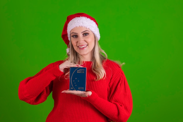 Jahresendreise Junge hübsche blonde Frau in Weihnachtsmütze, die einen brasilianischen Pass in den Händen hält