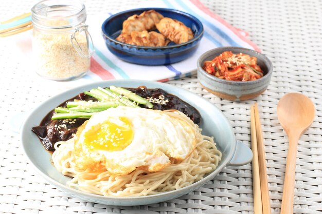 Jajang Myeon oder JJajangmyeon Koreanische Nudel mit schwarzer Bohnensauce, serviert mit Gurke und Sesam