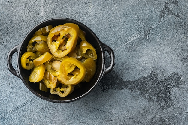 Jalapenos em conserva e fatiado, em fundo cinza, vista de cima plana lay