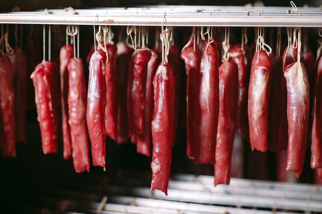 Foto jamón ahumado al horno. producción de salchichas en la fábrica.