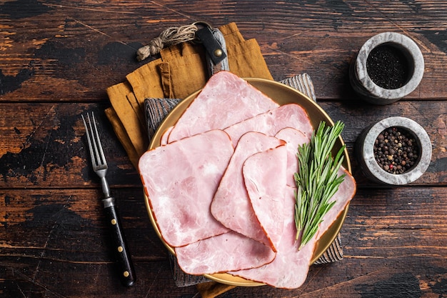 Jamón de carne de cerdo en rodajas cuadradas en un plato Fondo de madera Vista superior