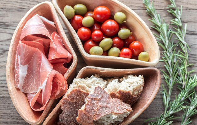 Jamon com aperitivos no fundo de madeira