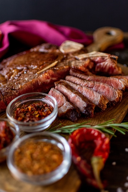 Foto jamón y condimentos en una mesa de madera.