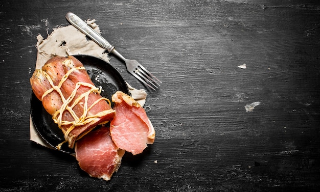 Jamón picado con un tenedor el plato viejo.