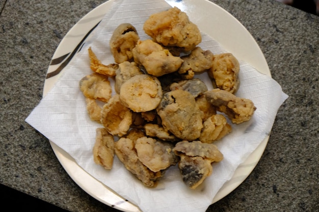 jamur merang goreng. cogumelo portabella frito. cogumelo de palha frito. comida vegana. no prato branco