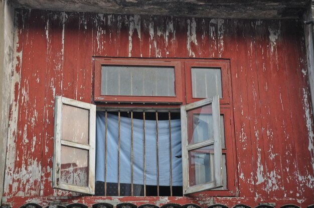 Janela aberta da velha casa de madeira vermelha no Vietnã