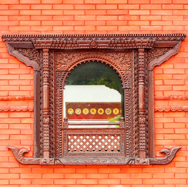 Janela bonita na parede de tijolo vermelho de um templo budista público na China