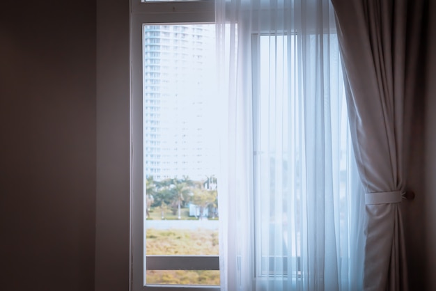 Foto janela com cortinas ou cortinas cortina pela cama, conceito de decoração de interiores.