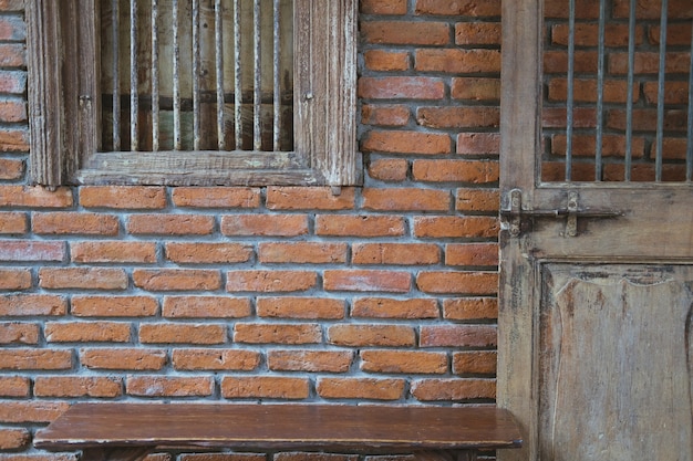 Janela da porta de madeira velha &amp; parede de tijolo