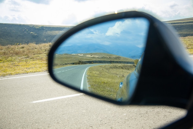 Foto janela do carro com estrada sob o céu