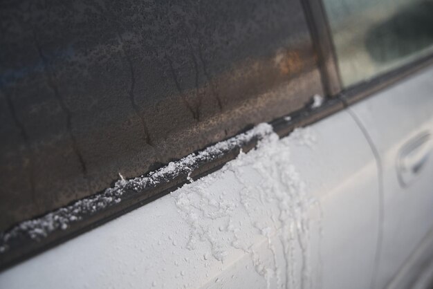 Janela do carro molhada Vidro do veículo coberto com neve derretida e água