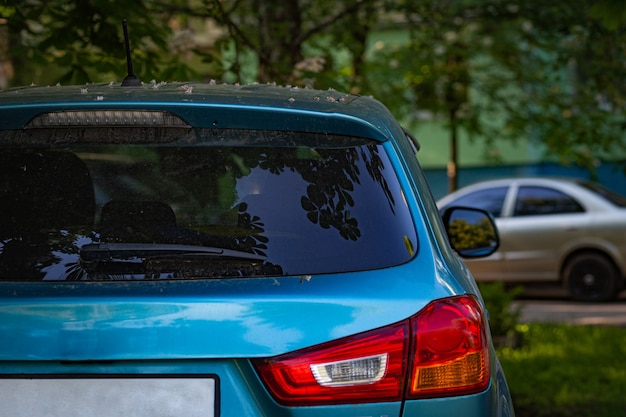 Foto janela traseira do carro azul estacionado na rua em dia ensolarado de verão, vista traseira. mock-up para adesivo ou decalques