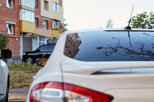 Janela traseira do carro branco estacionado na rua em um dia ensolarado de verão, vista traseira. Mock-up para adesivo ou decalques