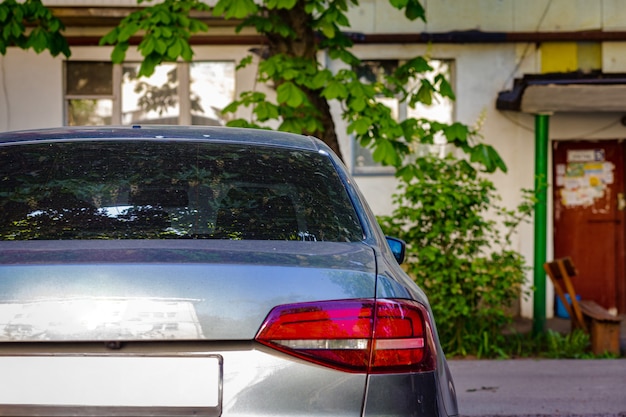 Foto janela traseira do carro cinza estacionado na rua em um dia ensolarado de verão, vista traseira. mock-up para adesivo ou decalques