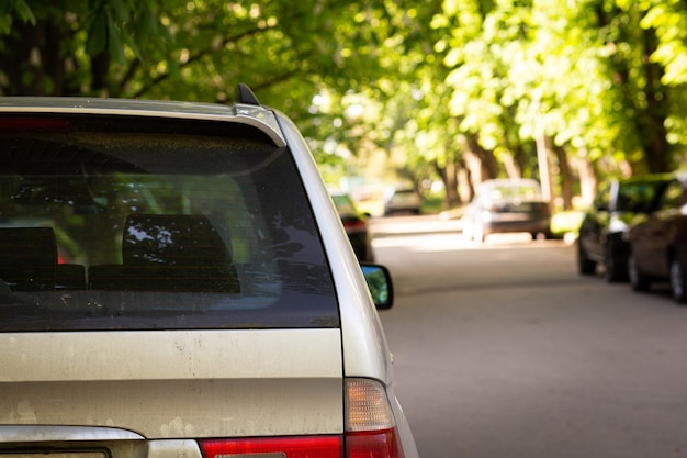 Foto janela traseira do carro cinza estacionado na rua em um dia ensolarado de verão, vista traseira. mock-up para adesivo ou decalques