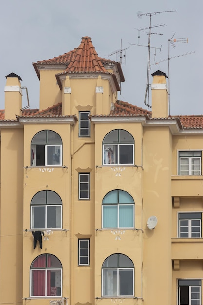 Janelas de apartamentos residenciais de um prédio de apartamentos europeu amarelo