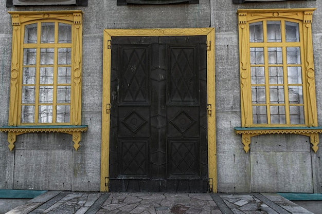 Casa cinza com janelas e portas de madeira