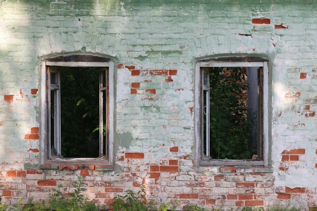 Janelas quebradas de uma casa de tijolos abandonada