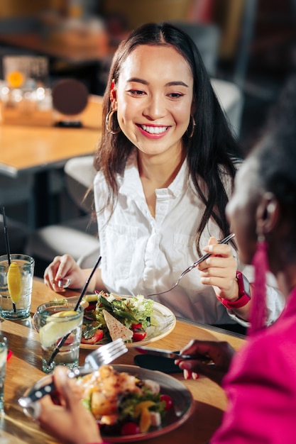 Foto jantar com amigos mulher de negócios radiante jantando com os amigos em um bom restaurante