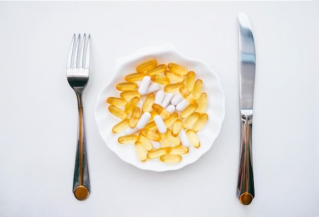 Jantar com pílulas com uma faca e um garfo. O conceito de perder peso com pílulas ou uso regular